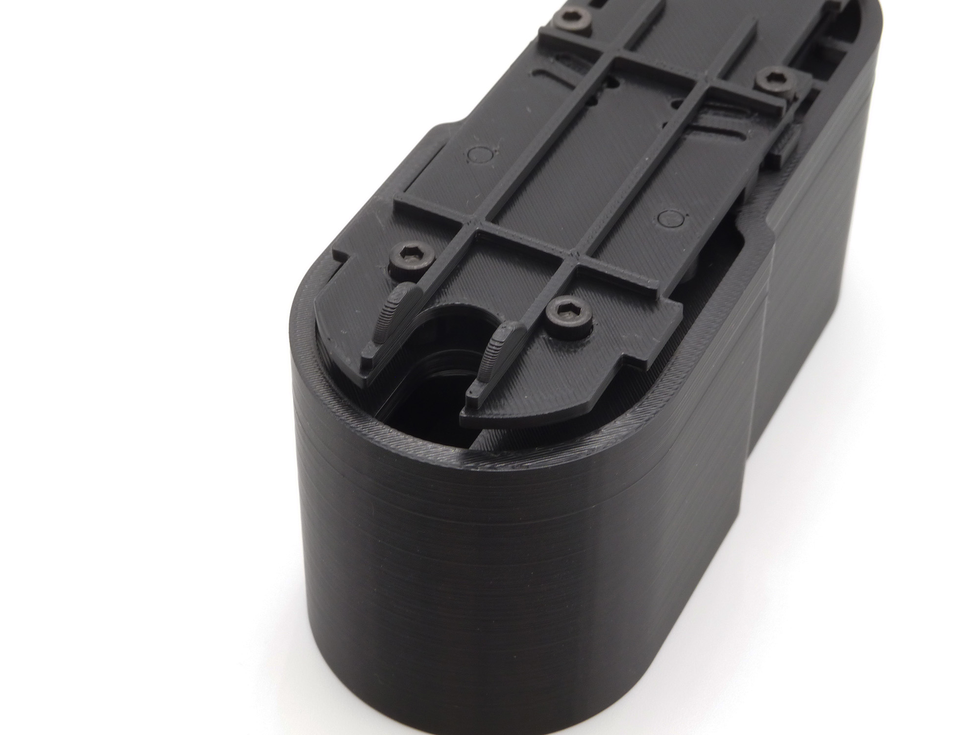 A top-side view of the buttstock extension, with a focus on the hole designed to have cabling or wires threaded through it