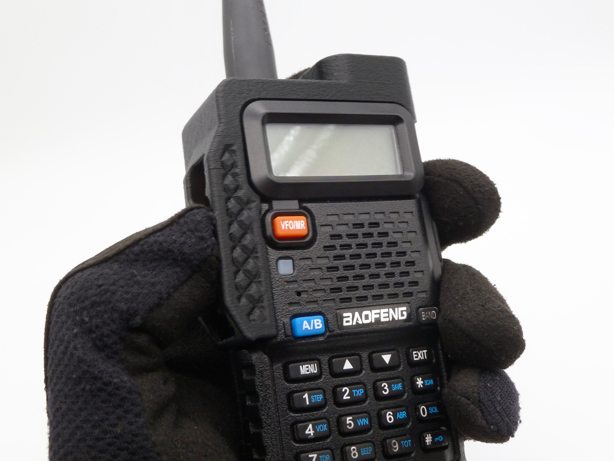 A second shot of a gloved hand holding onto the radio equipped with a UV5R guard